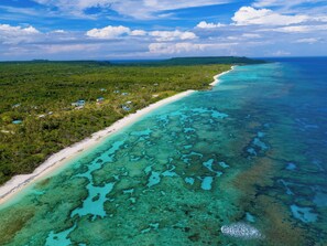 Aan het strand, wit zand, ligstoelen aan het strand, parasols