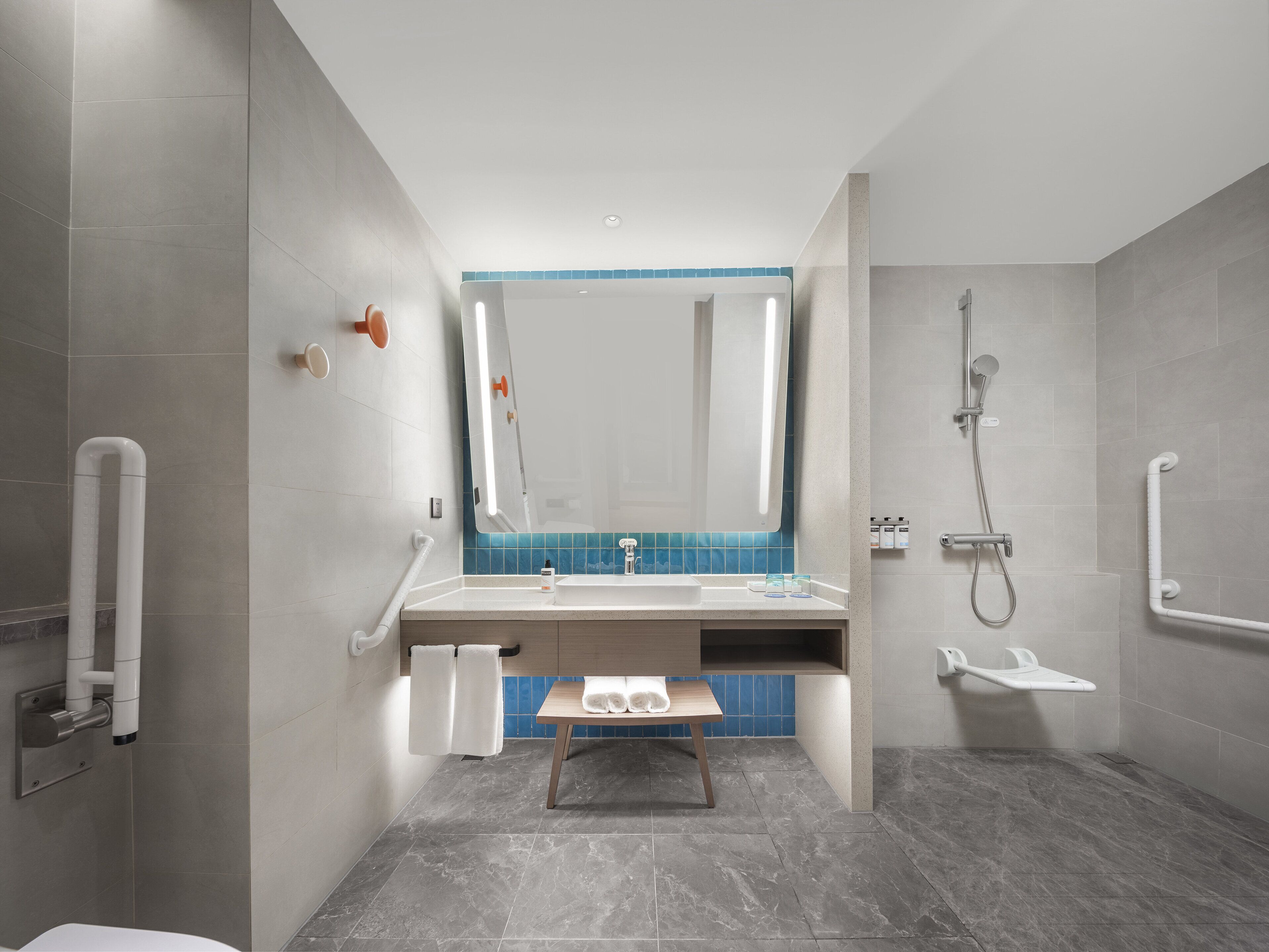 Un baño moderno con ducha, lavamanos y espejo.