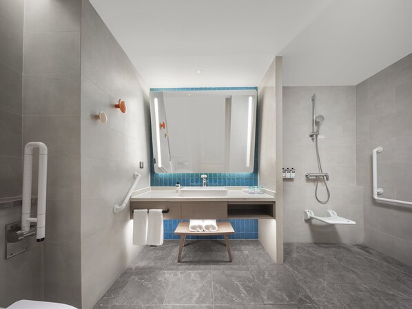 A modern bathroom with a shower, a sink, and a mirror.