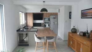 A modern kitchen with a central island, stainless steel appliances, and a pendant light. - Contemporary villa, 5' town center and beach 10 minutes by bike. (Capbreton)