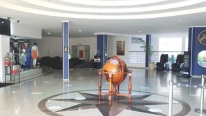 A spacious lobby with a central decorative globe, a reception desk, and a seating area. - Suite Golden Dolphin Grand - EUEMCALDAS (Caldas Novas)