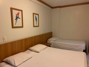 A hotel room with two single beds, a wooden headboard, and two framed bird paintings on the wall. - Suite Golden Dolphin Grand - EUEMCALDAS (Caldas Novas)