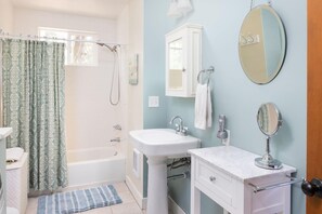 Een bad/douchecombinatie, een haardroger, handdoeken