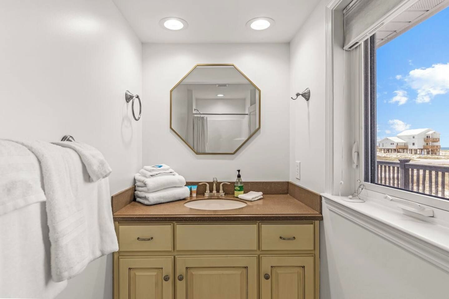 A bathroom with a sink, mirror, and towel rack.