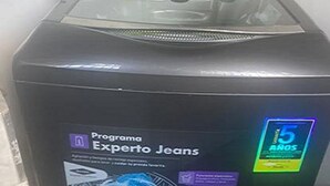 Une machine à laver noire dotée d’un écran numérique et d’une étiquette indiquant « Programme Expert Jeans ».
