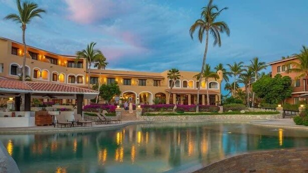 A hotel with a swimming pool, palm trees, and a courtyard with outdoor seating. - Private Pool, Hotel Services & Steps to Beach (San Jose del Cabo)