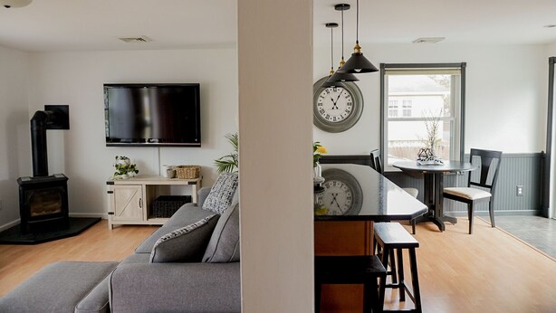 Una sala de estar moderna con una televisión de pantalla plana, una chimenea y un sofá.