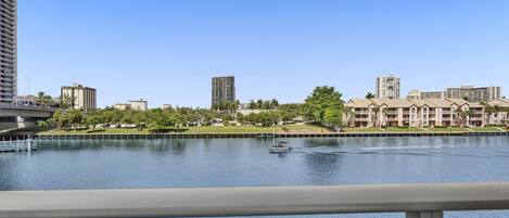 A waterfront view with a river, buildings, and a bridge.