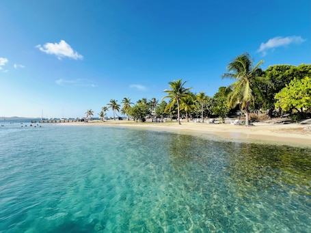 On the beach, sun-loungers, beach towels. Luxury Beachfront Condo with Pool and Hot Tub