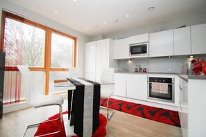 Enjoy meals in the kitchen with a microwave and dining area featuring a glass table and comfortable seating.