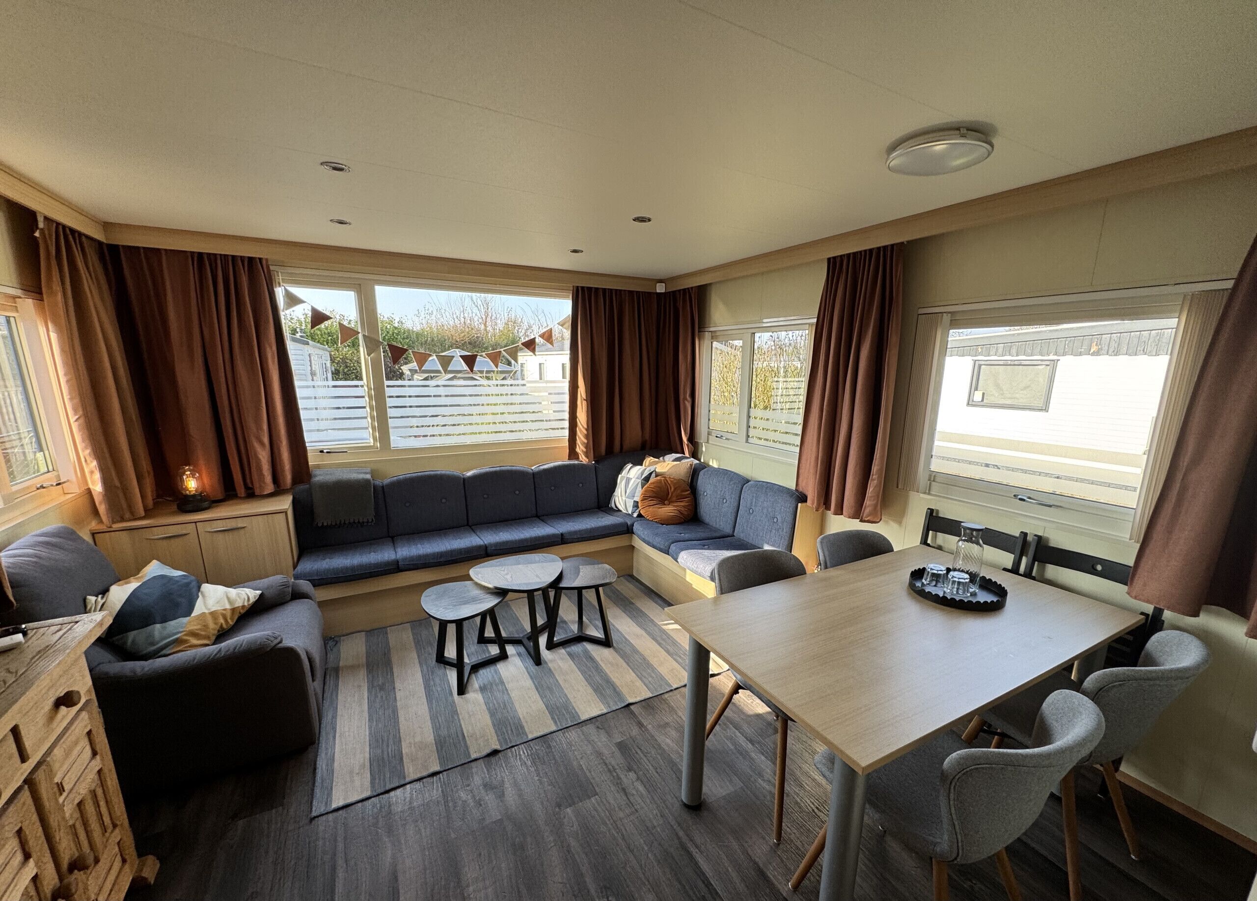 A cozy RV interior with a sofa, a dining table, and a small seating area.