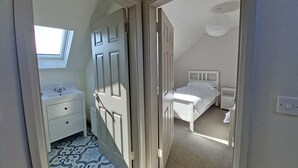 Une chambre à coucher avec un lit, une table de chevet et une fenêtre.