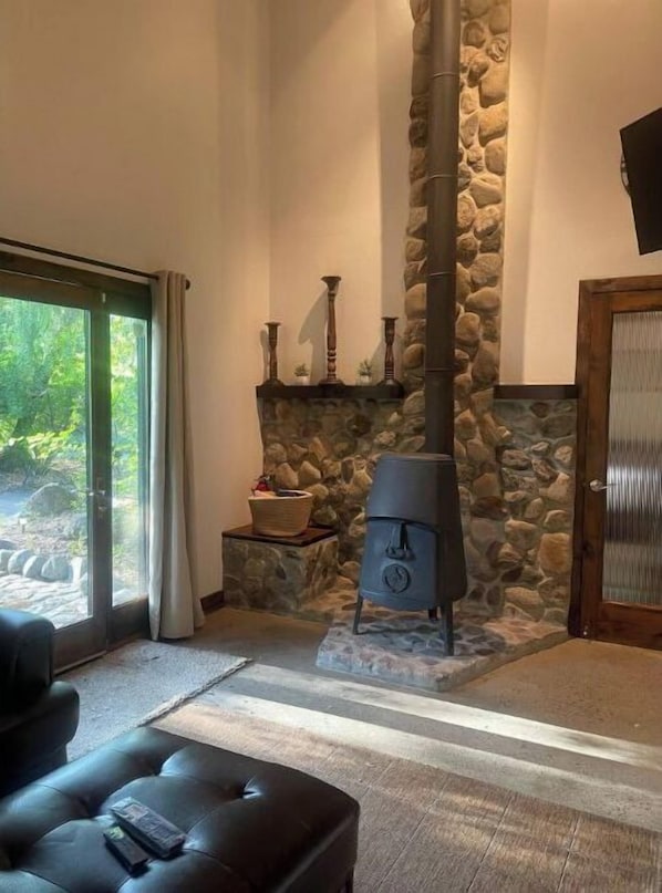 A cozy room with a stone fireplace, a large window, and a comfortable seating area.