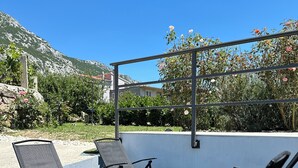 A poolside area with lounge chairs and a metal pergola. - Natura-Gata,Omiš-small stone apartman with swimming pool (Gata)