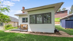 Ein eingeschossiges Haus mit Terrasse und einer kleinen Holzterrasse.