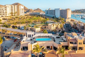 A hotel with a rooftop pool, outdoor seating, and a view of the marina.