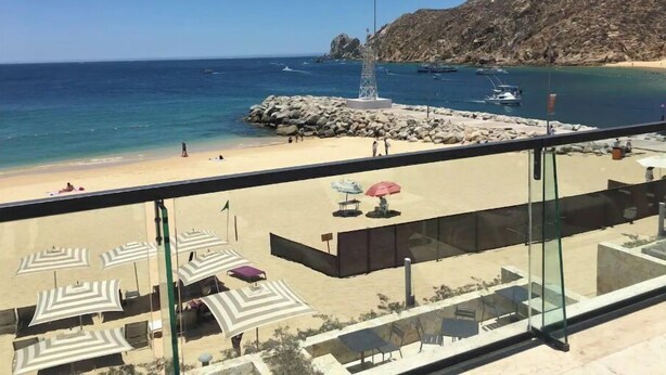 A beach view from a balcony with outdoor seating and umbrellas. - Marina View Open Studio Suite on Marina 645SF walk everywhere! NEW Rooftop Pool (Cabo San Lucas)