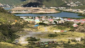 A coastal town with a mix of residential and commercial buildings, a river, and hills in the background.