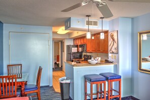 Enjoy meals in the kitchen with a central island and dining area nearby, featuring a table and chairs.