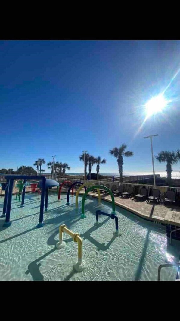 Relax by the pool surrounded by a low barrier and circular water features.