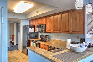 Enjoy cooking in this well-equipped kitchen with a refrigerator, microwave, oven, and sink.