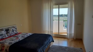 A bedroom with a bed, a window with curtains, and a view of a balcony. - AIRPORT to Comme à la maison 2, 5 minutes from the airport (Nouaceur)