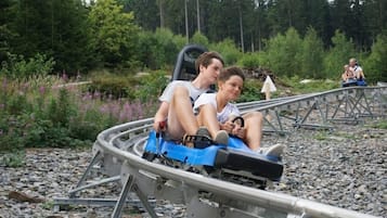 A roller coaster with passengers seated in a blue car.