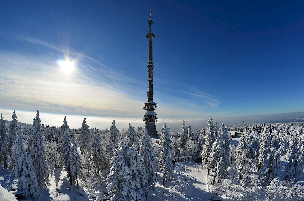 Eine verschneite Landschaft mit einem hohen Turmgebäude.