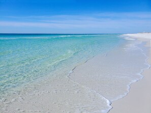 A beach with clear turquoise water and white sand.