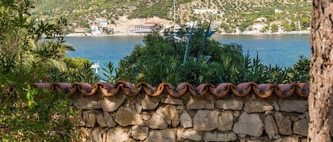 A stone wall with a view of a coastal town and a body of water.