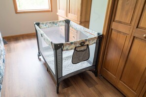 Cozy space for little ones, featuring a portable crib with a mesh side and quilted mattress.