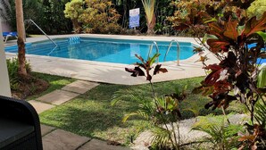 Una piscina con un cartello che indica 'No Diving', circondata da vegetazione lussureggiante e un'area patio piastrellata.