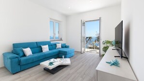 Una sala de estar moderna con un sofá azul, una mesa de centro y un televisor.