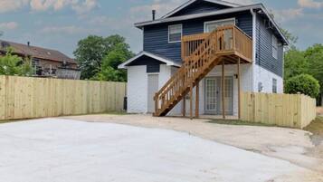 A two-story house with a wooden staircase leading to the front door.