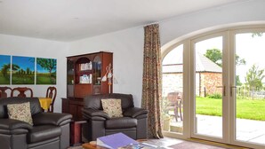 A living room with two leather sofas, a wooden cabinet, and a coffee table with magazines.