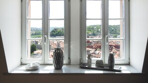 Una habitación con dos ventanas amplias que dan a una vista urbana.
