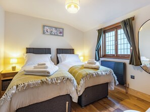 A double bed with two nightstands, a window with curtains, a radiator, and a wall-mounted picture. - Snowdrop Lodge -UK32959 (Ashford)
