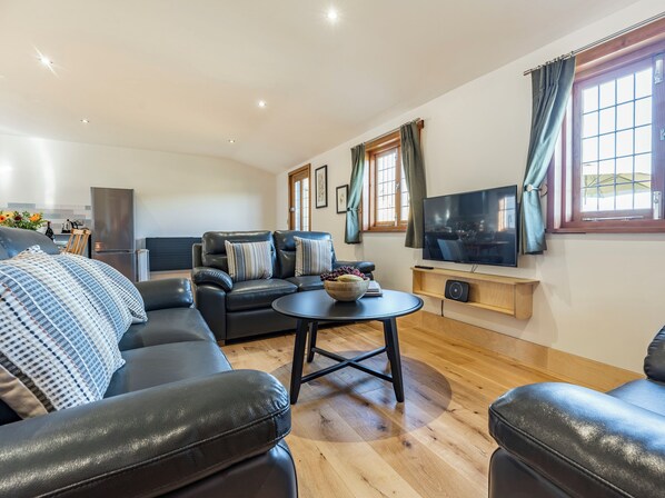 Ein modernes Wohnzimmer mit einer Couch, einem Couchtisch und einem Fernseher.