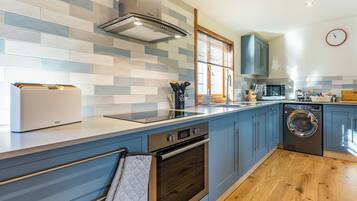 A modern kitchen with a built-in oven, microwave, and washing machine.