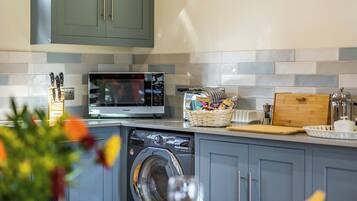 A compact kitchen with a microwave, toaster, and washing machine.