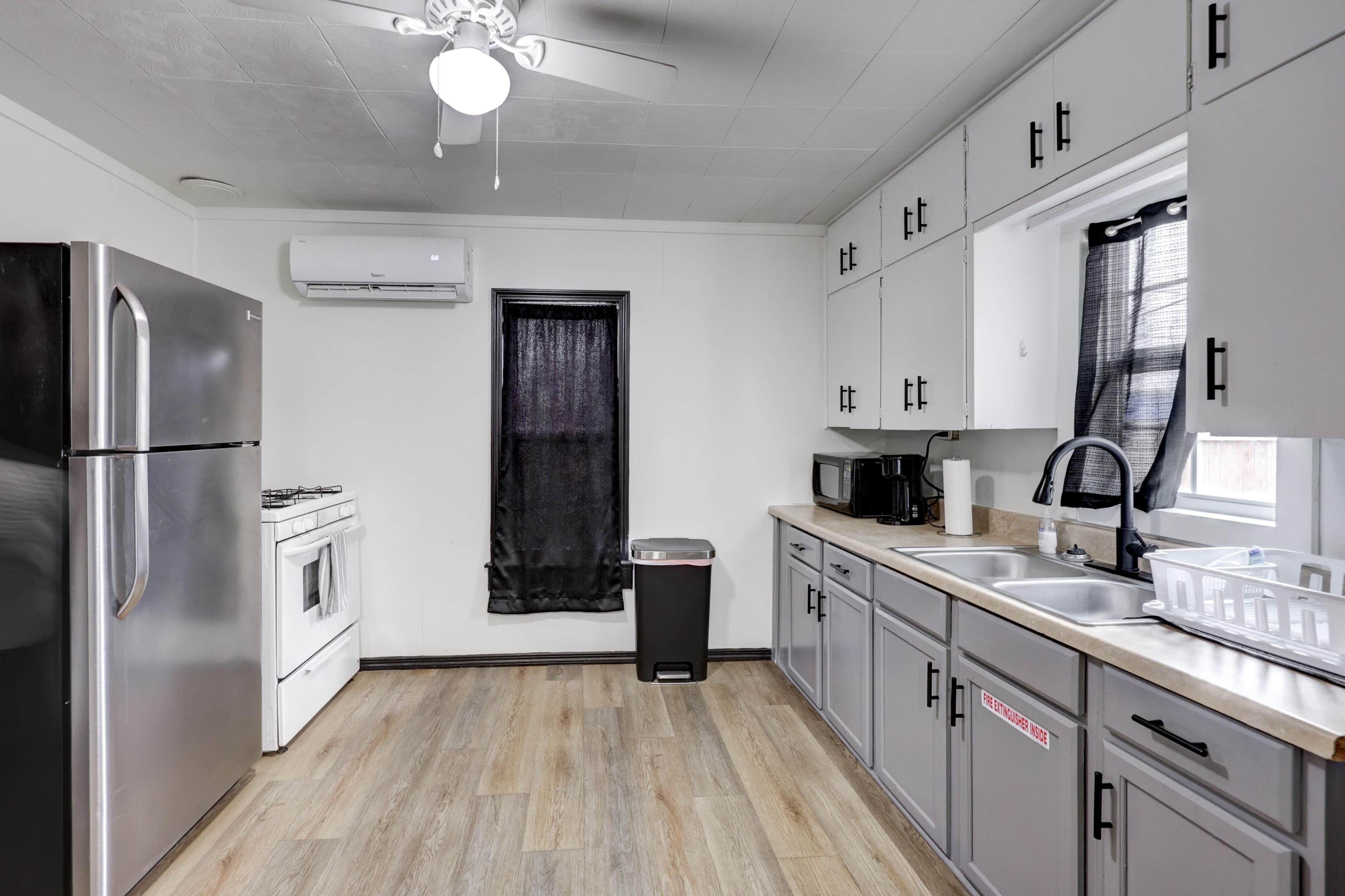 A modern kitchen with stainless steel appliances, a microwave, and a sink.