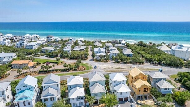 Uma área residencial costeira com casas e vista clara para o oceano.