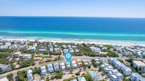 Vista aérea de uma área residencial costeira com casas e uma praia.