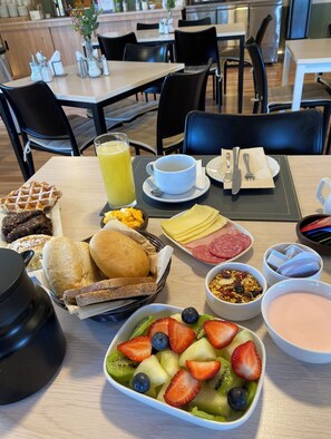 A breakfast buffet with waffles, pastries, fruit, and a variety of spreads. - Hotel El Almendro (Buin)