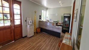 Una zona de recepción con un escritorio de madera, una decoración con forma de estrella, un refrigerador y una vitrina de cristal.