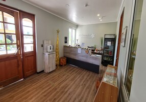 Una zona de recepción con un escritorio de madera, una decoración con forma de estrella, un refrigerador y una vitrina de cristal.