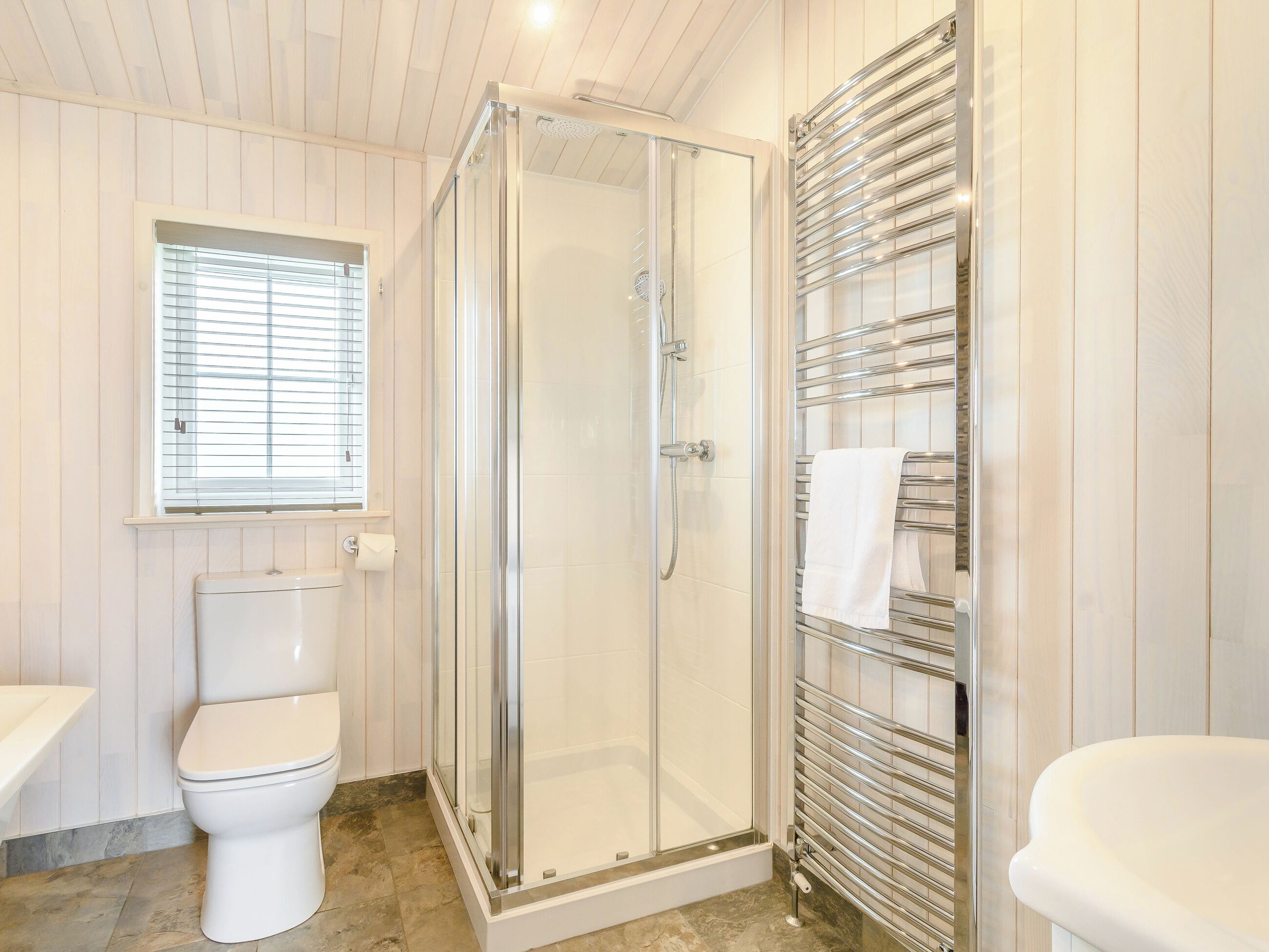 Une salle de bain moderne avec une douche à parois de verre, des toilettes et un lavabo.