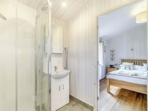 Un dormitorio con cama de madera, una mesita de noche y un velador.