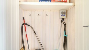Une pièce où l’on trouve un aspirateur, une serpillière et un filtre à eau posés sur le sol.