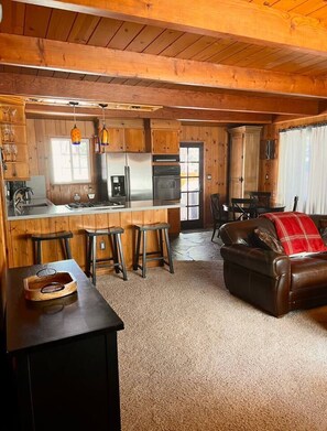 Ein gemütliches Blockhaus-Interieur mit Küche, Essbereich und Wohnzimmer.